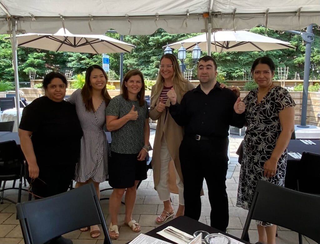 from left to right: Marla, Mary (from Montage Support Services), myself, Anna & Mark (from DANI), and Padi from Durlaksar.all posing together standing in a group photo at an outdoor resturant.