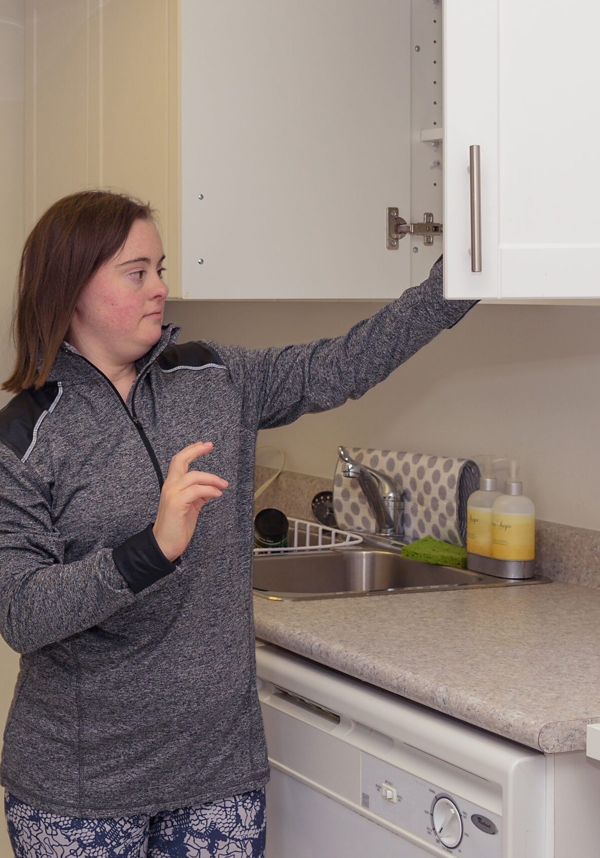 Here is Jenna in her kitchen, getting something from the top cupboard.